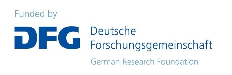 Eine Wissenschaftlerin und ein Wissenschaftler arbeiten hinter einer Glasfassade und mischen Chemikalien mit Großgeräten.